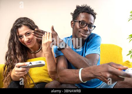 Una giovane coppia felice dà un alto cinque in festa mentre gioca ai videogiochi insieme a casa. Foto Stock