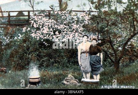 Intitolato A Highland Washing, l'immagine mostra due donne che bollono il bucato all'aperto in una pentola. Circondata da fiori primaverili e da una recinzione rustica, la scena evoca un'epoca tranquilla e passata di vita domestica rurale, catturando le tradizionali pratiche di lavaggio delle Highlands con tranquilla dignità. Pubblicato intorno al 1908 come parte della serie affidabile di William Ritchie & Sons Ltd. Da una cartolina originale. Foto Stock