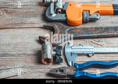 Ampia gamma di utensili idraulici su fondo in legno. Copia spazio per il testo Foto Stock