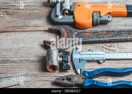 Ampia gamma di utensili idraulici su fondo in legno. Copia spazio per il testo Foto Stock