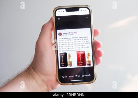 Un utente visualizza un post sui social media di Donald Trump su X precedentemente Twitter sul suo smartphone, in cui il presidente degli Stati Uniti presenta il suo profumo Victory 45-47 Foto Stock