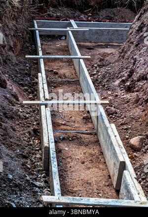 Costruzione di fondazioni. Forme in legno pronte per il versamento del primo strato di cemento. Foto Stock