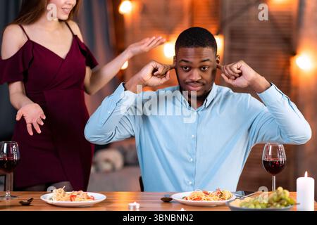 La coppia interrazziale che sostiene. Giovani amanti multiculturali che hanno conflitti durante Date al Ristorante Foto Stock