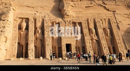 Abu Simbel, Egitto - 25 aprile 2025: Vista ravvicinata delle colossali statue della regina Nefertari e del faraone Ramses II sulla facciata del Tempio di Nefertar Foto Stock
