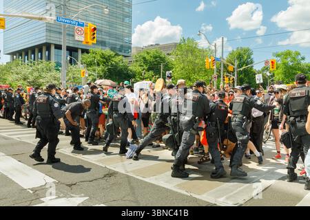 Toronto, Canada, 1° luglio 2025. La polizia litiga con i manifestanti vicino alla legislatura dell'Ontario il giorno del Canada. I manifestanti hanno denunciato la legislazione provinciale che dicono permetterà l'estrazione di risorse che viola la loro sovranità e minaccia la loro terra. Colin N. Perkel/Alamy Live News Foto Stock