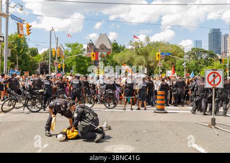 Toronto, Canada, 1° luglio 2025. La polizia arresta un manifestante vicino alla legislatura dell'Ontario il giorno del Canada. I manifestanti hanno denunciato la legislazione provinciale che dicono permetterà l'estrazione di risorse che viola la loro sovranità e minaccia la loro terra. Colin N. Perkel/Alamy Live News Foto Stock
