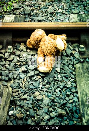 Un orsacchiotto giace su un binario ferroviario. Foto Stock