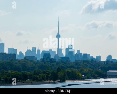Una vista telefotografica dello skyline di Toronto durante una mattinata soleggiata e nebulosa sulle rive del lago Ontario. CN Tower e il crescente skyline di Toronto. Foto Stock