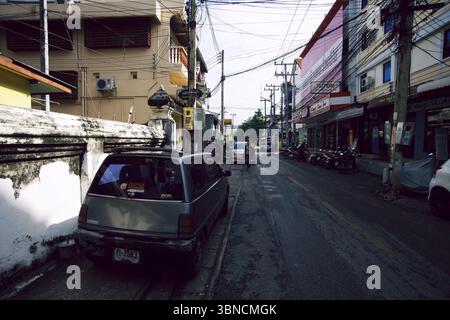 Chiang mai Narrow Street Scene con cavi sospesi e veicoli parcheggiati Foto Stock