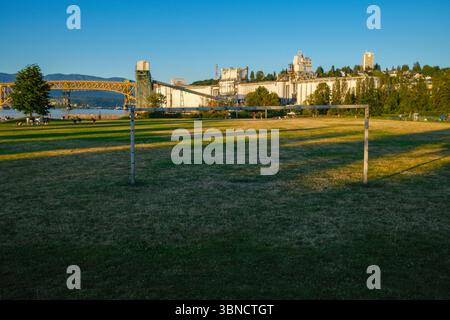 Il campo da calcio del New Brighton Park di Vancouver, British Columbia. L'Iron Workers Memorial Bridge e il Viterra Cascadia Terminal sono dietro. Foto Stock