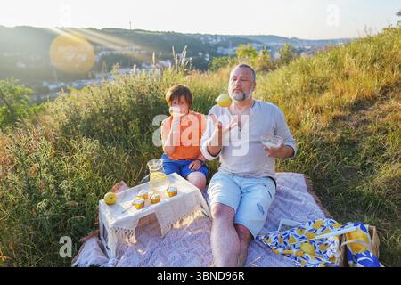 Picnic estivo in natura momenti gioiosi in famiglia con cibo e risate. Foto Stock