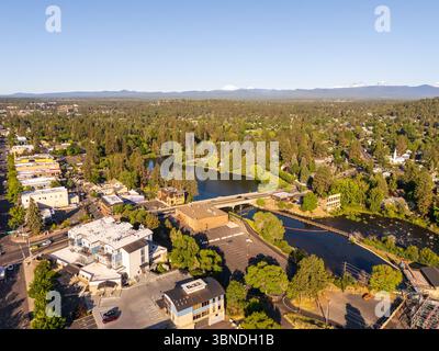 Bend, Oregon, Stati Uniti. Vista aerea dello specchio d'acqua e del commercio cittadino e degli affari con i vulcani sullo sfondo Foto Stock