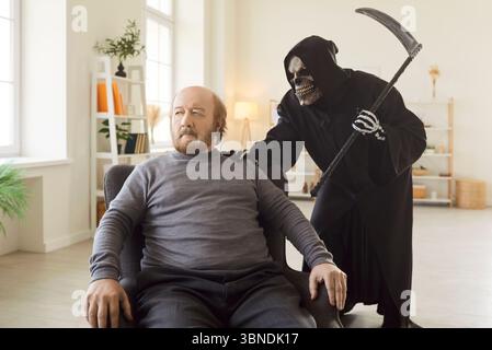 Uomo anziano in attesa, morente, triste Mietitore della morte con falce che trova nuova vittima, spalla toccata Foto Stock