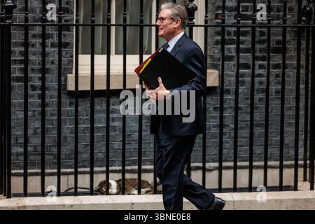 Downing Street, Londra, Regno Unito. 2 luglio 2025. Il primo ministro britannico, Keir Starmer, parte dal numero 10 di Downing Street per partecipare alla sessione delle domande del primo ministro (PMQ) nella camera dei comuni, passando davanti a un sonnolento Larry the Cat. Crediti: Amanda Rose/Alamy Live News Foto Stock