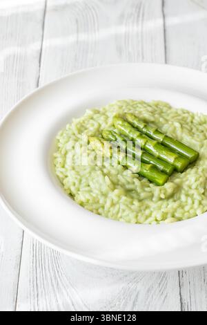 Risotto cremoso con punte di asparagi verdi, guarnito e presentato splendidamente Foto Stock