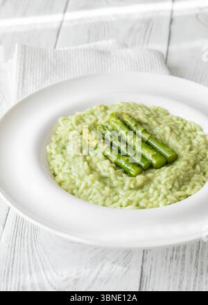 Risotto cremoso con punte di asparagi verdi, guarnito e presentato splendidamente Foto Stock