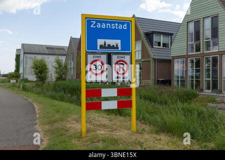 Questa foto vivace mostra un cartello con i limiti della città di Zaanstad con un'icona distintiva del mulino a vento, accanto a una zona di velocità di 30 km/h e a un parcheggio limitato, perfetto Foto Stock