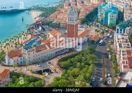 Vista aerea della città costiera con edifici in stile mediterraneo, torre dell'orologio, porticciolo, passeggiata tropicale con palme e oceano a Sunset Town, Phu Foto Stock