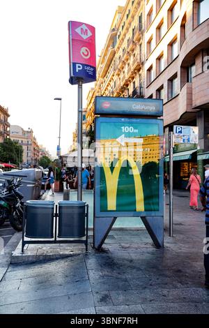 Navigazione in città: Metro e fast food segnalano 100 metri di distanza McDonalds Barcellona Spagna 29.06.2025 Foto Stock