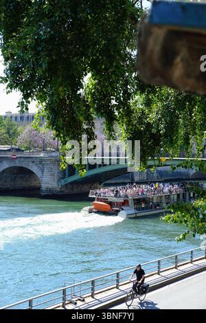 Turisti che si godono una gita in barca lungo la Senna a Parigi. Viste estive dalla crociera turistica in una giornata di sole Foto Stock