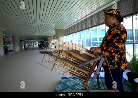 Yogyakarta, Indonesia - 21 dicembre 2024: Un musicista suona angklung, un tradizionale strumento musicale sundanese di Giava occidentale, nella lobby di Yogya Foto Stock