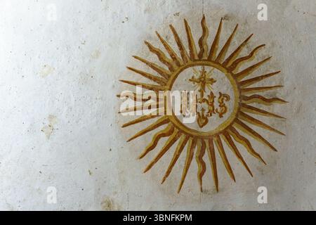Una vista dettagliata di un dipinto dorato di un'esplosione di sole con il Christogram IHS, che simboleggia il nome di Gesù Cristo, situato nella Chiesa del Gesu Foto Stock