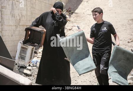 Tulkarm, Palestina. 2 luglio 2025. Le famiglie palestinesi portano con sé i loro effetti personali mentre fuggono dal campo profughi di Tulkarm. Le forze israeliane hanno permesso ai residenti di recuperare i loro effetti personali dopo aver emesso avvisi di demolizione per diverse case, nel mezzo di un'offensiva durata mesi in Cisgiordania che ha allontanato circa 35.000 palestinesi dalle loro case nel campo profughi di Tulkarm. Credito: SOPA Images Limited/Alamy Live News Foto Stock