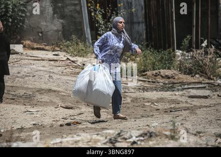 Tulkarm, Palestina. 2 luglio 2025. Un palestinese porta i suoi effetti personali mentre fuggono dal campo profughi di Tulkarm. Le forze israeliane hanno permesso ai residenti di recuperare i loro effetti personali dopo aver emesso avvisi di demolizione per diverse case, nel mezzo di un'offensiva durata mesi in Cisgiordania che ha allontanato circa 35.000 palestinesi dalle loro case nel campo profughi di Tulkarm. Credito: SOPA Images Limited/Alamy Live News Foto Stock