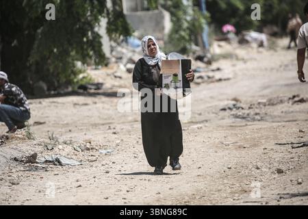 Tulkarm, Palestina. 2 luglio 2025. Un palestinese porta i suoi effetti personali mentre fuggono dal campo profughi di Tulkarm. Le forze israeliane hanno permesso ai residenti di recuperare i loro effetti personali dopo aver emesso avvisi di demolizione per diverse case, nel mezzo di un'offensiva durata mesi in Cisgiordania che ha allontanato circa 35.000 palestinesi dalle loro case nel campo profughi di Tulkarm. Credito: SOPA Images Limited/Alamy Live News Foto Stock