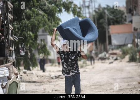 Tulkarm, Palestina. 2 luglio 2025. Un palestinese porta i suoi effetti personali mentre fugge dal campo profughi di Tulkarm. Le forze israeliane hanno permesso ai residenti di recuperare i loro effetti personali dopo aver emesso avvisi di demolizione per diverse case, nel mezzo di un'offensiva durata mesi in Cisgiordania che ha allontanato circa 35.000 palestinesi dalle loro case nel campo profughi di Tulkarm. Credito: SOPA Images Limited/Alamy Live News Foto Stock