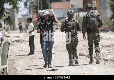 Tulkarm, Palestina. 2 luglio 2025. Le famiglie palestinesi portano con sé i loro effetti personali mentre fuggono dal campo profughi di Tulkarm. Le forze israeliane hanno permesso ai residenti di recuperare i loro effetti personali dopo aver emesso avvisi di demolizione per diverse case, nel mezzo di un'offensiva durata mesi in Cisgiordania che ha allontanato circa 35.000 palestinesi dalle loro case nel campo profughi di Tulkarm. Credito: SOPA Images Limited/Alamy Live News Foto Stock