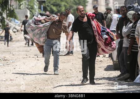Tulkarm, Palestina. 2 luglio 2025. Le famiglie palestinesi portano con sé i loro effetti personali mentre fuggono dal campo profughi di Tulkarm. Le forze israeliane hanno permesso ai residenti di recuperare i loro effetti personali dopo aver emesso avvisi di demolizione per diverse case, nel mezzo di un'offensiva durata mesi in Cisgiordania che ha allontanato circa 35.000 palestinesi dalle loro case nel campo profughi di Tulkarm. Credito: SOPA Images Limited/Alamy Live News Foto Stock
