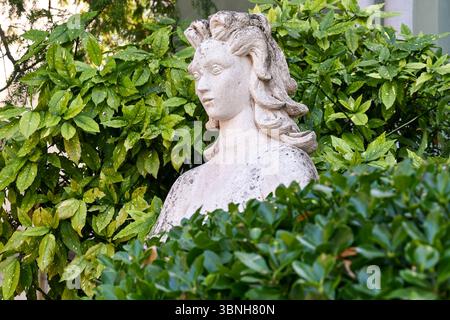 Busto femminile tra siepi nei Giardini della Biennale, o Giardini napoleonici, in estate, Venezia, Veneto, Italia Foto Stock