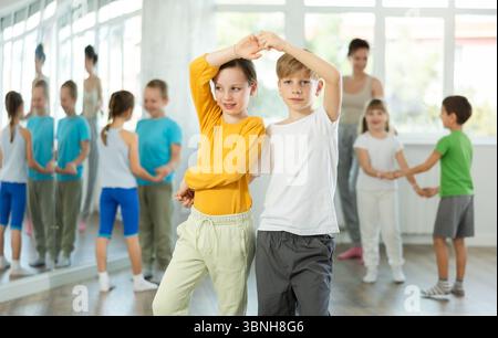 I bambini in età preadolescente imparano a ballare il valzer in coppia nella classe di coreografia Foto Stock
