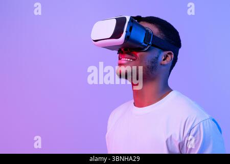 Tecnologie moderne per l'intrattenimento. Uomo nero eccitato che indossa occhiali vr guardando da parte Foto Stock
