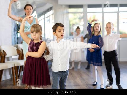 Entusiasti bambini preadolescenti che ballano valzer a coppie nella scuola di danza Foto Stock