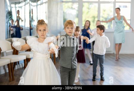 Entusiasti bambini preadolescenti che ballano valzer a coppie nella scuola di danza Foto Stock