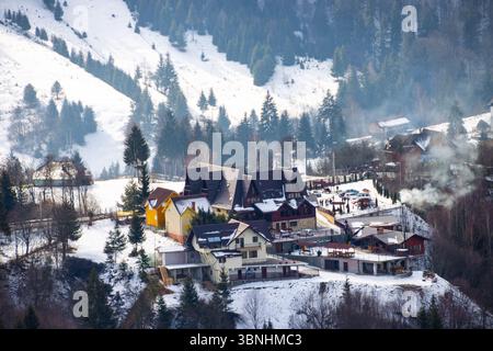 Gruppo di case in montagna in un paesaggio invernale Foto Stock