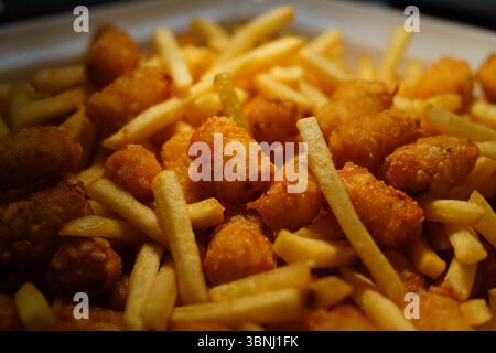 Patatine fritte croccanti d'oro e tortini – primo piano snack shot Foto Stock