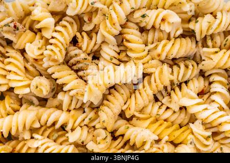 Una vista ravvicinata della pasta fusilli mette in risalto la sua trama intricata e la sua forma a spirale. Ideale per gli sfondi, cattura l'essenza di sano e natu Foto Stock