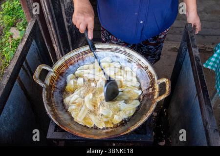 Tradizionali pacchi di foglie di banana alla griglia su una stufa a carbone nel sud-est asiatico Foto Stock