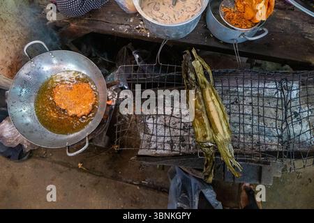 Tradizionali pacchi di foglie di banana alla griglia su una stufa a carbone nel sud-est asiatico Foto Stock