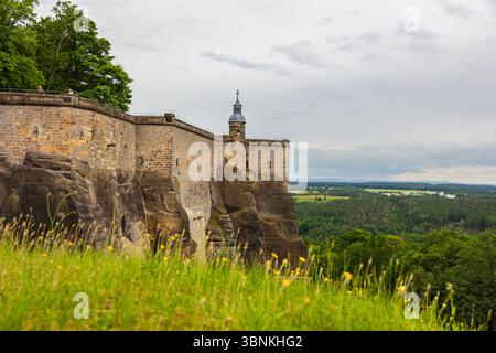 Fortezza di Königstein in Svizzera sassone, Germania – 6. Giugno 2025: Veduta del massiccio muro di pietra esterno e della torre difensiva della fortezza di Königstein perc Foto Stock