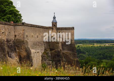 Fortezza di Königstein in Svizzera sassone, Germania – 6. Giugno 2025: Veduta del massiccio muro di pietra esterno e della torre difensiva della fortezza di Königstein perc Foto Stock