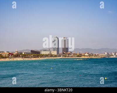 Spiaggia e costa di Barceloneta a Barcellona, con l'iconico Hotel Arts e i grattacieli della Mapfre Tower contro il cielo. Spagna. Foto Stock