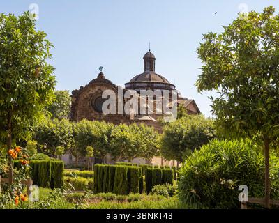 La cupola della Chiesa Parrocchiale militare della Cittadella del XVIII secolo sorge sopra i lussureggianti e formalmente disposti alberi del Parc de la Ciutadella a Barcellona Foto Stock