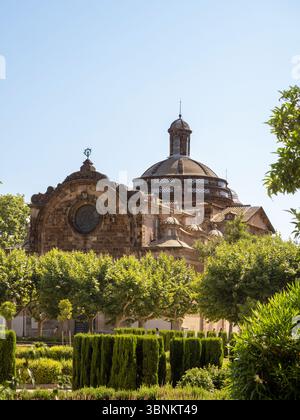 La cupola della Chiesa Parrocchiale militare della Cittadella del XVIII secolo sorge sopra i lussureggianti e formalmente disposti alberi del Parc de la Ciutadella a Barcellona Foto Stock