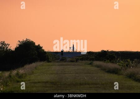 Un cielo insolito e colorato senza nuvole su un percorso ciclabile Foto Stock