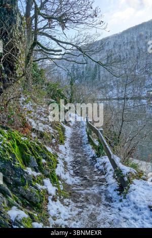 Romantico sentiero con recinzione presso il bacino idrico di Rur vicino a Heimbach nell'Eifel in inverno Foto Stock