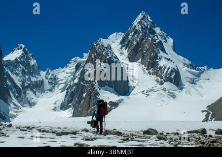 Alpinismo team di corda sul ghiacciaio neve fredda d'alta quota catena montuosa Tian-Shan arrampicata tra crepacci ramponi ascia di ghiaccio stretto crinale di neve Foto Stock
